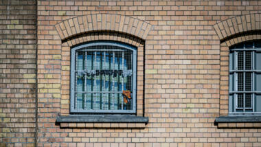 In einem vergitterten Fenster hängen Socken